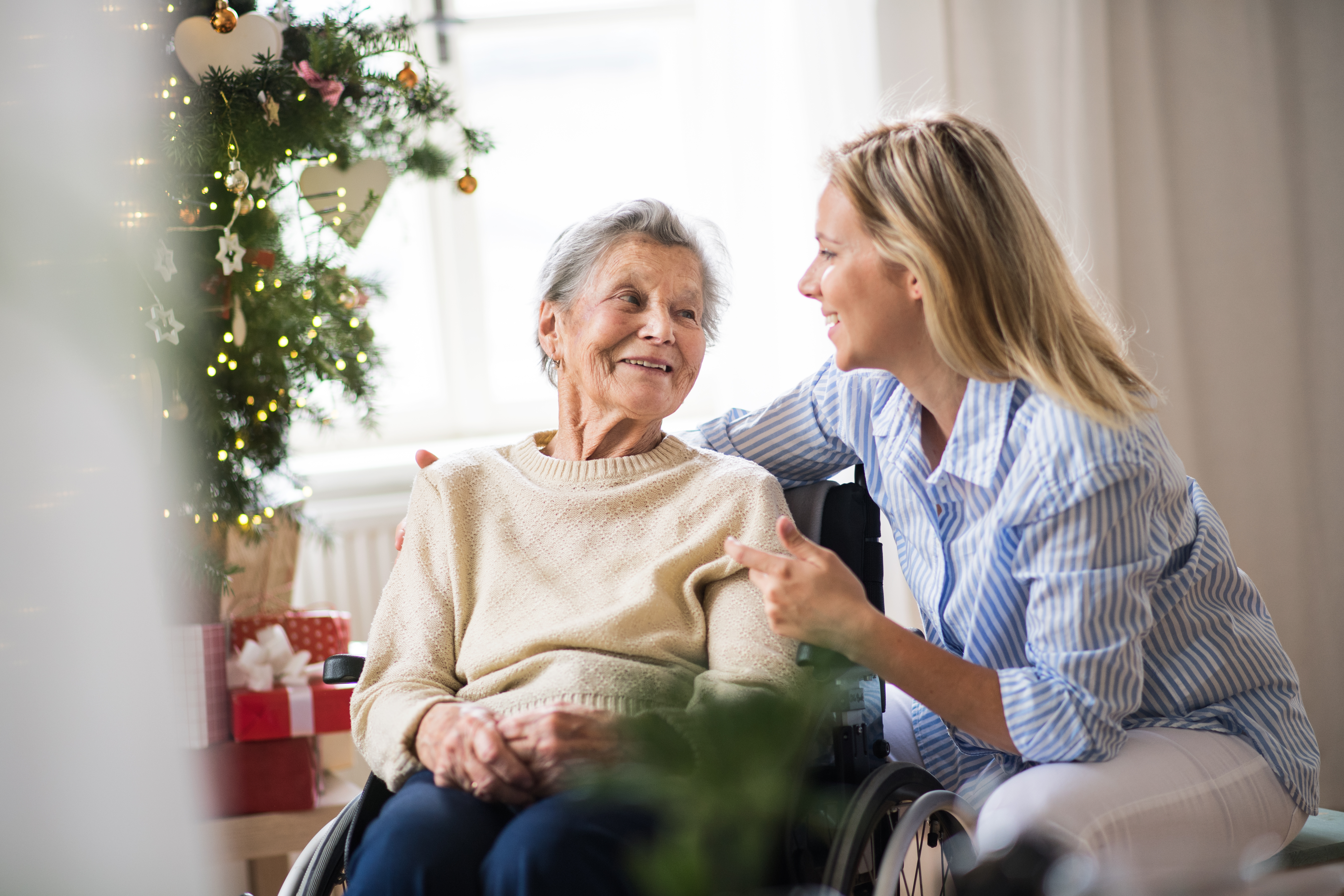 a senior woman in wheelchair with a health visitor